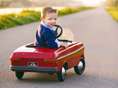 little boy in toy car